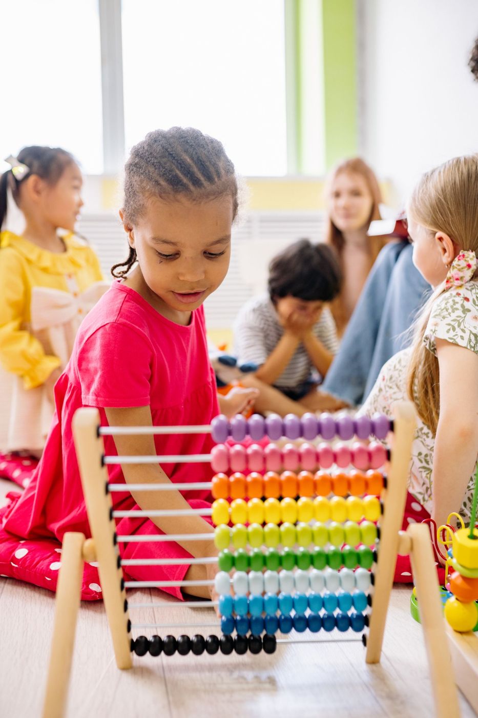 Children exploring an abacus together in class