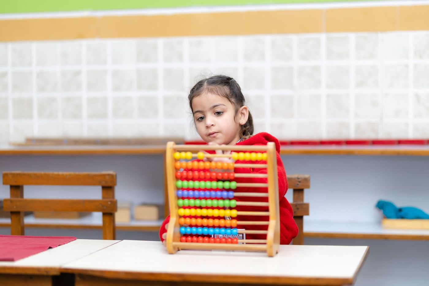 A young student working on her abacus in class